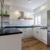 cocina moderna de planta abierta con azulejo tipo metro y porcelánico imitación madera en el suelo