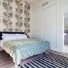 Dormitorio con papel pintado con motivos florales y baño en suite
