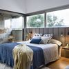 Dormitorio con ventanas en la pared del cabecero y mobilario a medida.