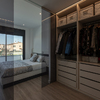 Dormitorio con vestidor abierto tras puertas de cristal ahumado