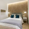 Dormitorio moderno con tira de led en el techo y lámparas colgantes