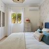 Dormitorio romántico con papel pintado de flores en el cabecero