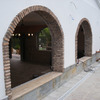 Lateral de la fachada compuesta de dos ventanas con arcos de ladrillo viejo.