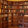 Librería semicircular en madera de Cerezo, con libros.