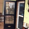 Puerta de paso abatible realizada con forja artística y cristal laminado de seguridad.
