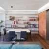 Salón comedor con paredes de ladrillo visto y estanterías voladas.