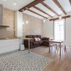 Salón y cocina de planta abierta con techo alto