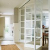 Puerta interior tipo acordeón blanca y de cristal para separar salón y cocina